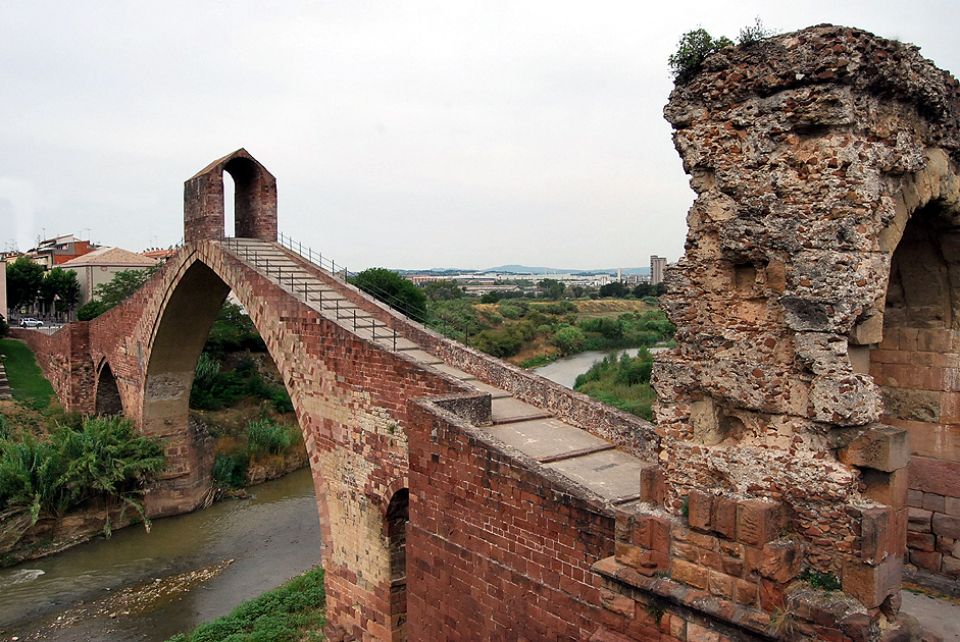 Martorell, cruce de caminos entre el Llobregat y el Anoia Martorell es un municipio del Baix Llobregat situado en un punto estratégico de la red viaria y ferroviaria de Cataluña, justo en la confluencia de los ríos Llobregat y Anoia, al norte de la comarca y a unos 30–35 km de Barcelona. Con unos 28.500 habitantes y una superficie de 12,84 km², combina un núcleo histórico compacto —el barrio de La Vila— con barrios más recientes como El Pla, Torrent de Llops, Buenos Aires, Can Cases, Les Bòbiles o Portal d’Anoia. El término municipal se organiza en dos grandes zonas separadas por el Anoia: la parte sur, donde se encuentra el casco viejo y barrios tradicionales, y la parte norte, más llana y de expansión residencial e industrial. Martorell se ha consolidado como un importante centro industrial y logístico, con la presencia destacada de la planta de SEAT y de numerosas empresas auxiliares del automóvil, pero al mismo tiempo conserva elementos patrimoniales singulares como el Pont del Diable, con restos de origen romano, el Museo Municipal Vicenç Ros o la red de espacios verdes vinculados a los ríos. Todo ello le da un carácter de ciudad activa, bien comunicada y con mucha historia.